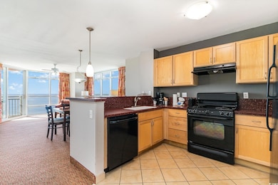 Kitchen featuring black appliances, light brown ca