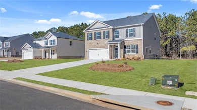 View of front facade with concrete driveway, board and batten siding, a front lawn, and a garage
