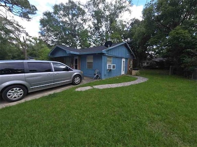 View of side of home with a lawn, cooling unit, and board and batten siding