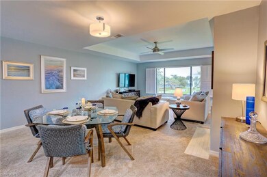 Dining space with a tray ceiling, light carpet, an