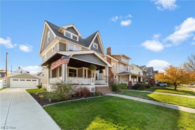 View of front of house featuring a garage, a front lawn, and a porch