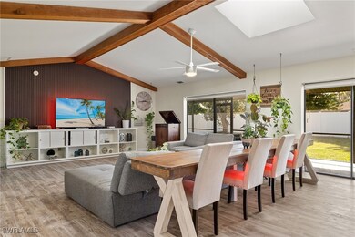 Dining space with lofted ceiling with skylight and