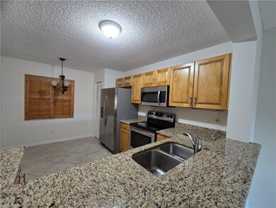 Kitchen featuring sink, hanging light fixtures, granite countertops, kitchen peninsula, and stainless-steel appliances.