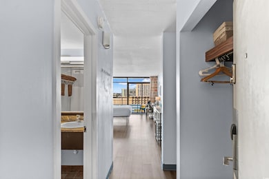 Hall featuring expansive windows, light wood-style floors, and a textured ceiling