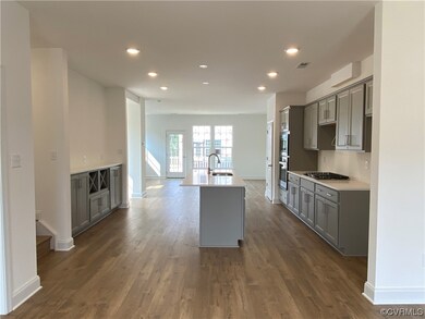 Kitchen with gas cooktop, stainless steel double oven, light countertops, and light hardwood floors