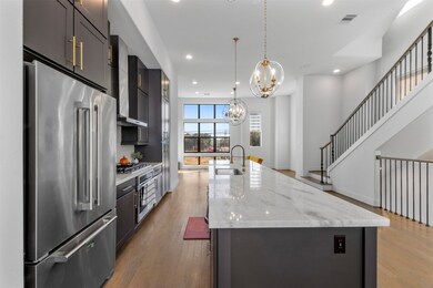 Modern kitchen showcasing sleek stainless steel appliances, including a refrigerator, microwave, and dishwasher. A perfect balance of style and practicality.
