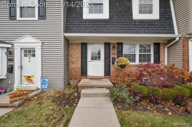 Entrance to property with roof with shingles, brick siding, and mansard roof