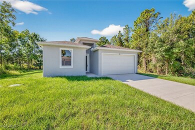 View of front of house featuring a front yard, a garage, stucco siding, and concrete driveway