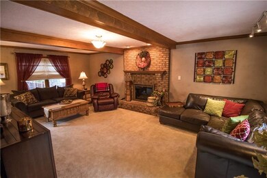 Real wood beams, brick gas fireplace in this large
