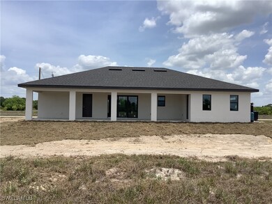 Rear view of house featuring stucco siding and a s