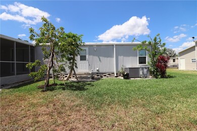 Back of property with central AC unit, a sunroom,