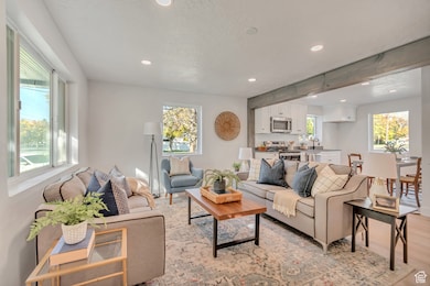 Living room featuring recessed lighting, light wood-style floors, and a textured ceiling