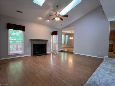 Large and bright living room with vaulted ceilings, sky lights and fireplace.  The perfect spot to cozy up with a book or watch a movie!!