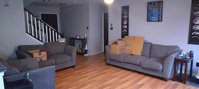 Living room featuring stairway, baseboards, and wo