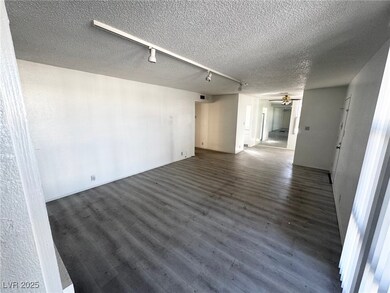 Empty room featuring ceiling fan, a textured ceili