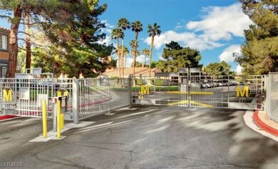 View of asphalt road with a gate, a gated entry, and curbs