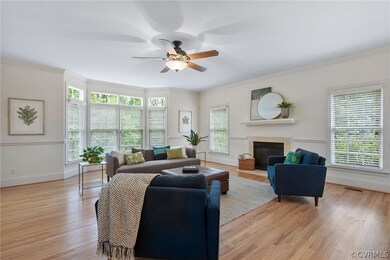 Living room featuring ceiling fan, light hardwood