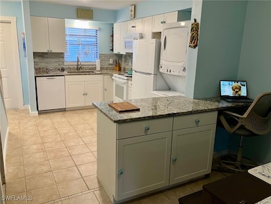 Kitchen featuring kitchen peninsula, white cabinet
