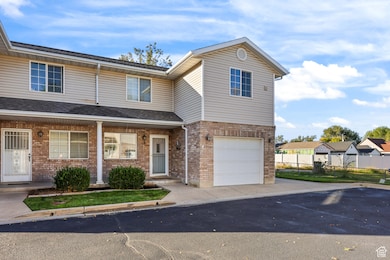 Traditional-style home featuring a porch, brick siding, an attached garage, driveway, and a shingled roof