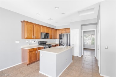 Kitchen with light countertops, a sink, stainless