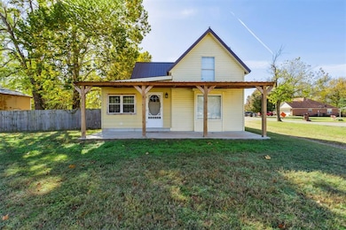 View of front facade featuring a front yard and a metal roof