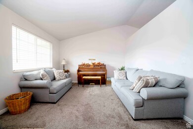 Carpeted living room with vaulted ceiling and baseboards