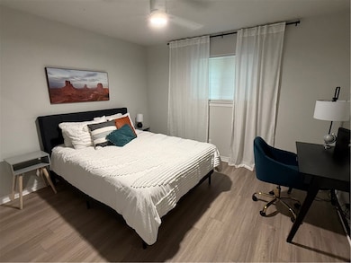 Bedroom featuring light wood-type flooring, a desk