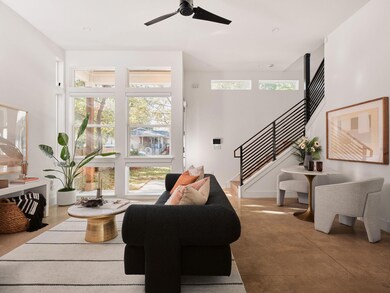 Living area featuring stairway, concrete floors, and ceiling fan