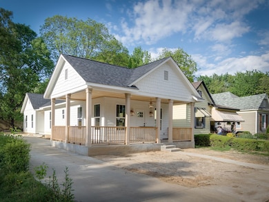 View of front facade featuring a porch and roof with shingles