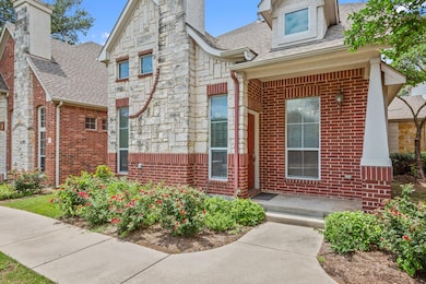 Property entrance featuring a shingled roof, bric