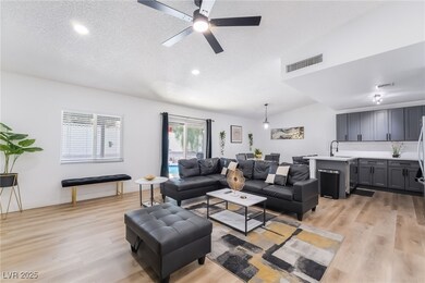 Living room with light wood-style flooring, a textured ceiling, a ceiling fan, recessed lighting, and lofted ceiling