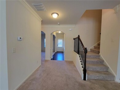 Entryway featuring carpet, visible vents, ornament