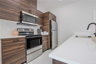 Kitchen with tasteful backsplash, sink, dark brown cabinetry, and appliances with stainless steel finishes