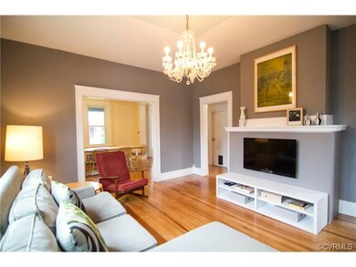 Living room looks into the kitchen and dining room, chandelier original to the home.