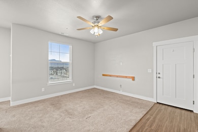 Spare room featuring ceiling fan, a textured ceiling, and light wood-type flooring