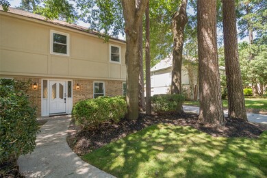 Landscaping in the front lawn features beautiful mature trees and zoysia grass.