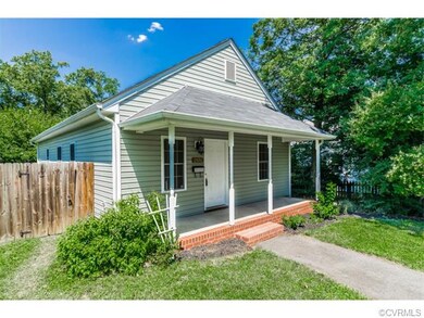 The home features a full covered front porch and a