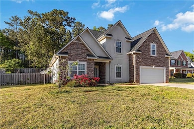 View of front of house featuring driveway, stone s