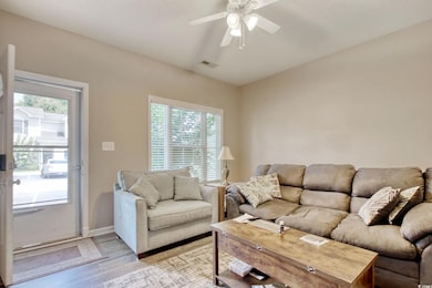 Living room with light wood-style flooring and ceiling fan