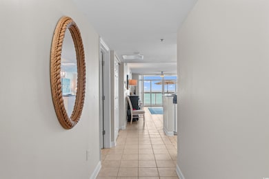 Hallway featuring light tile patterned floors and baseboards