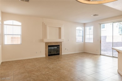 Unfurnished living room featuring a tiled fireplac