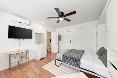 Bedroom with a wall mounted air conditioner, ligh