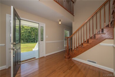 Wide foyer with lovely turned stairway.