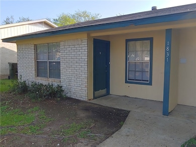 View of exterior entry featuring brick siding