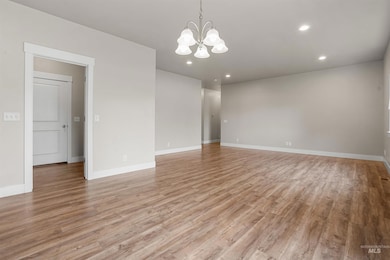 Unfurnished room with a chandelier, light wood-type flooring, and recessed lighting