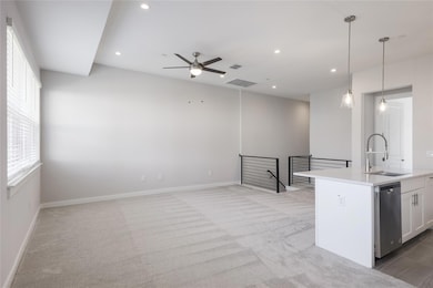 Kitchen featuring light colored carpet, hanging l