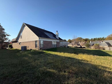 View of side of property with central AC and a yar