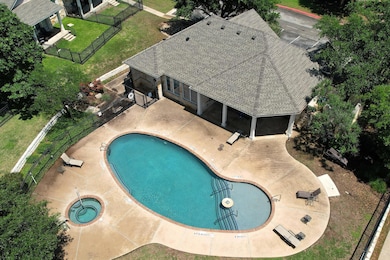Community pool featuring a hot tub and a patio ar