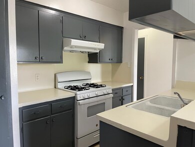 Kitchen featuring a sink, light countertops, rang