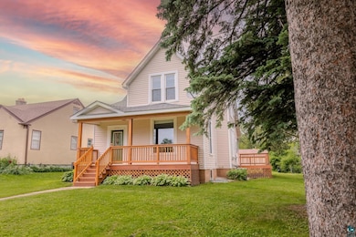 View of front of house featuring covered porch and a yard